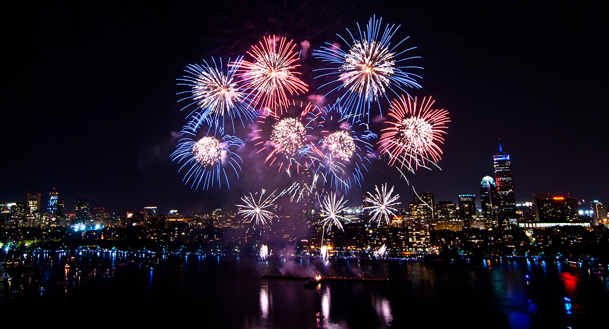 a fireworks display over the Boston skyli e