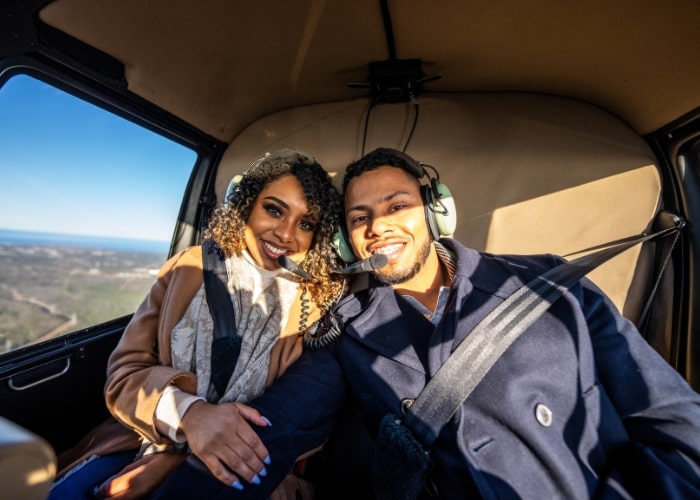 man and woman sitting in a helicopter