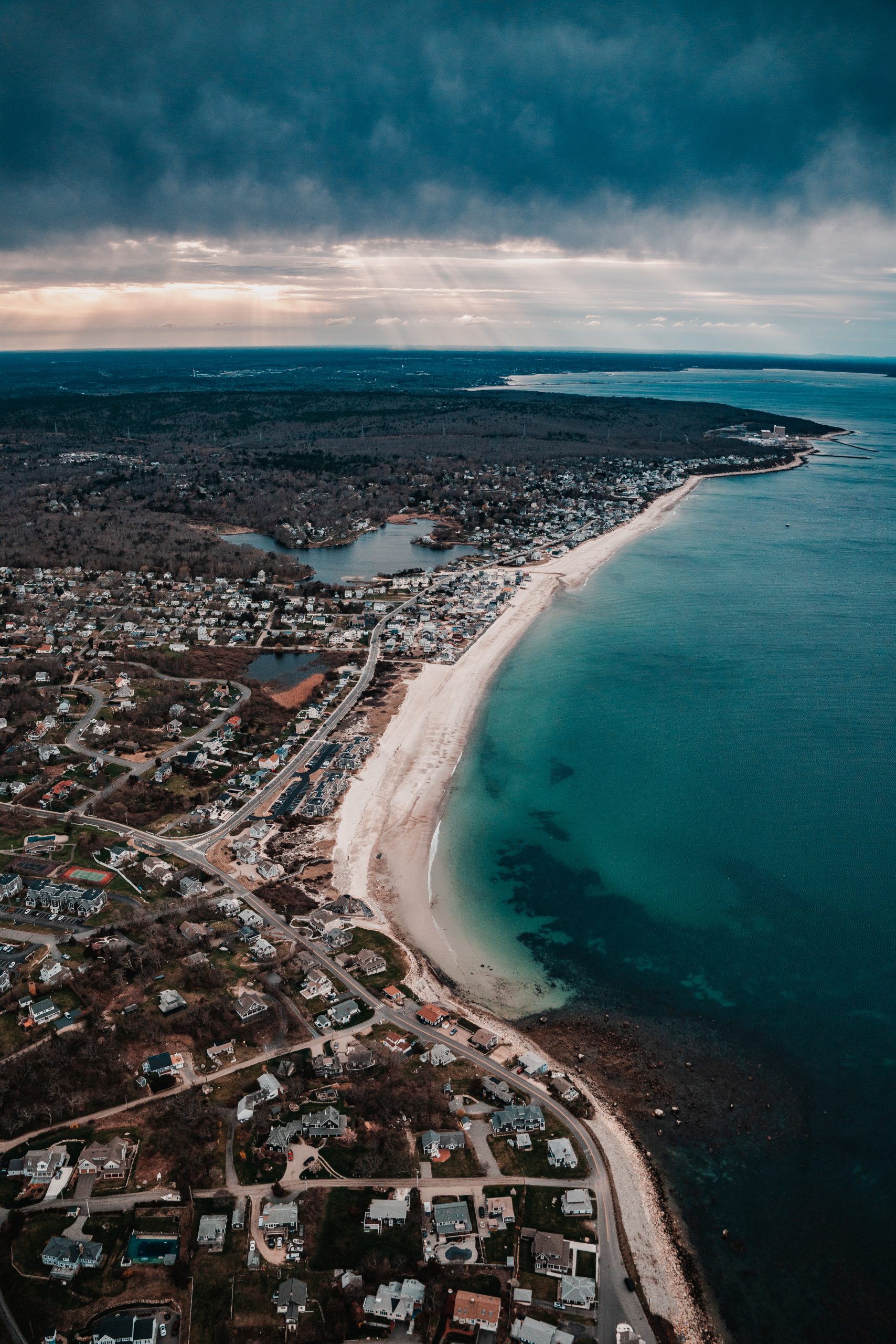 Breathtaking helicopter view of Cape Cod’s coastline featuring deep blue ocean waters, sandy shores, and scenic coastal landscapes from above.